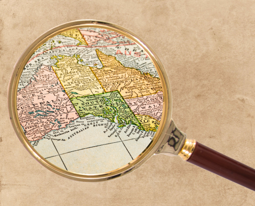 Magnifying glass revealing a map of the Australian states on a background of aged paper.
